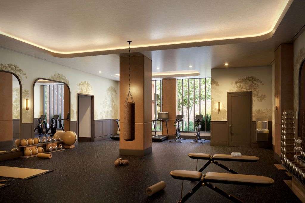 Fitness center at The Village West condominiums with free weights, cardio machines and yoga stations with large windows.